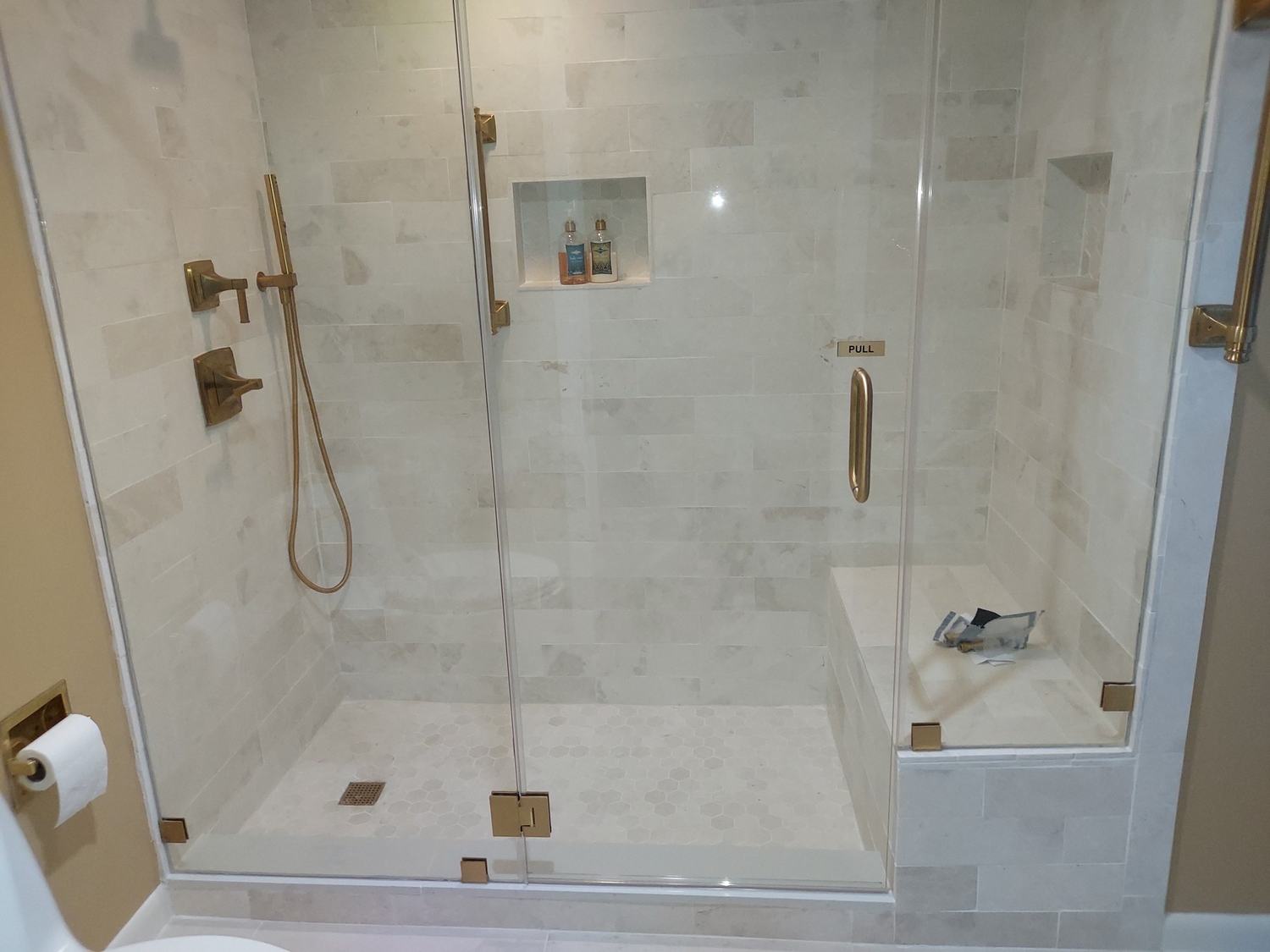 Completed walk-in tiled shower with glass enclosure